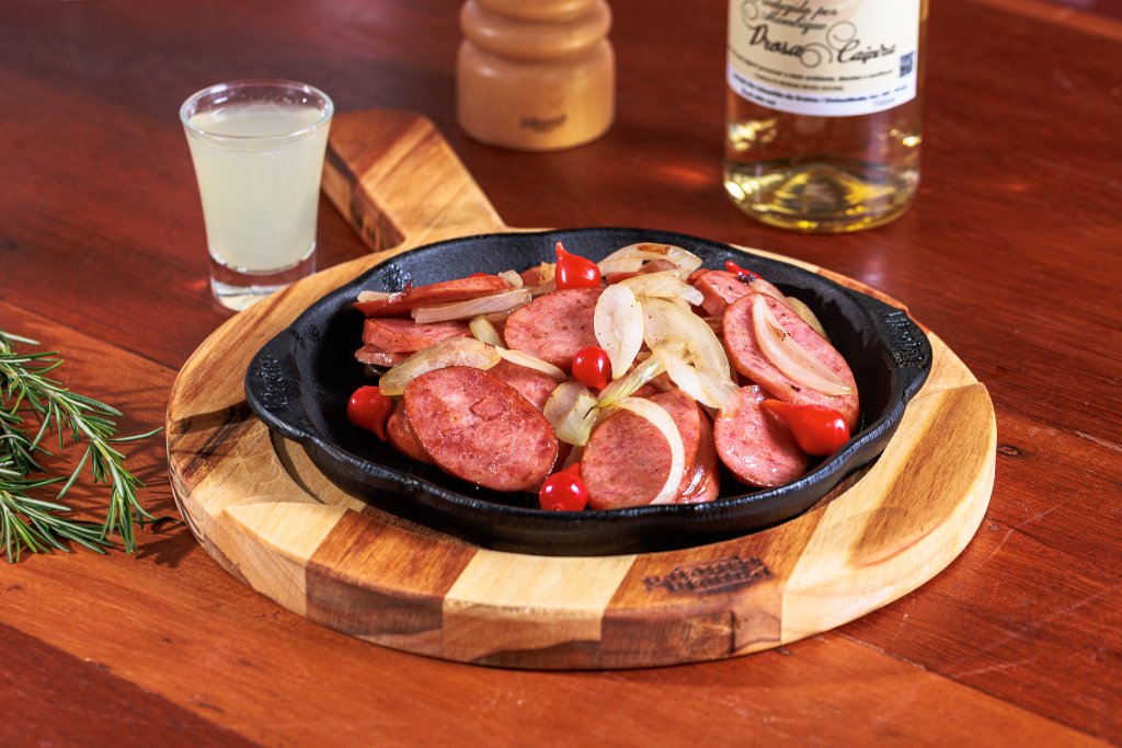 Porção de linguiça calabresa acebolada flambada na cachaça