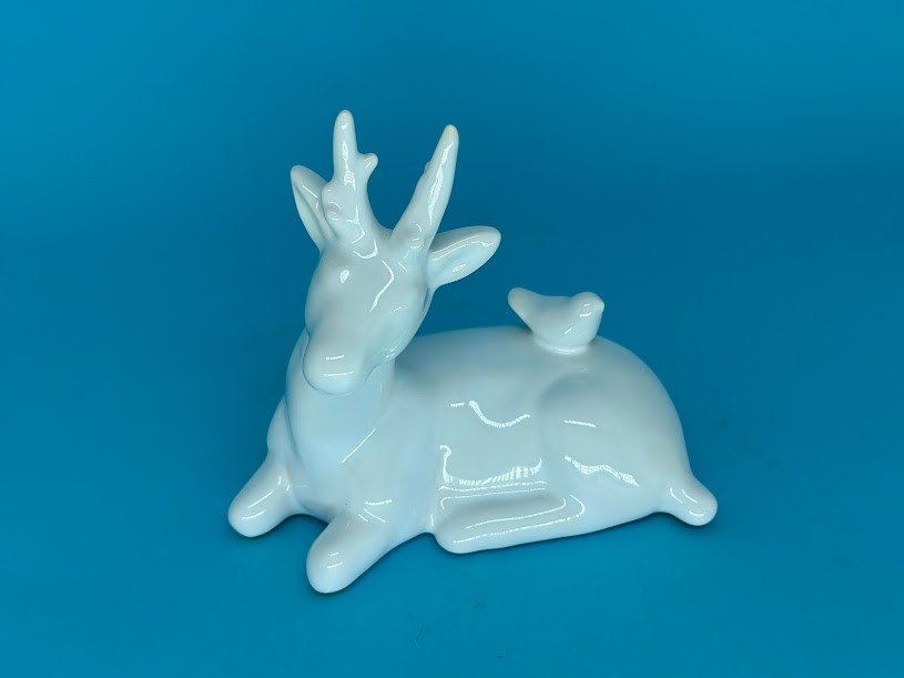 RENA DEITADA COM PÁSSARO